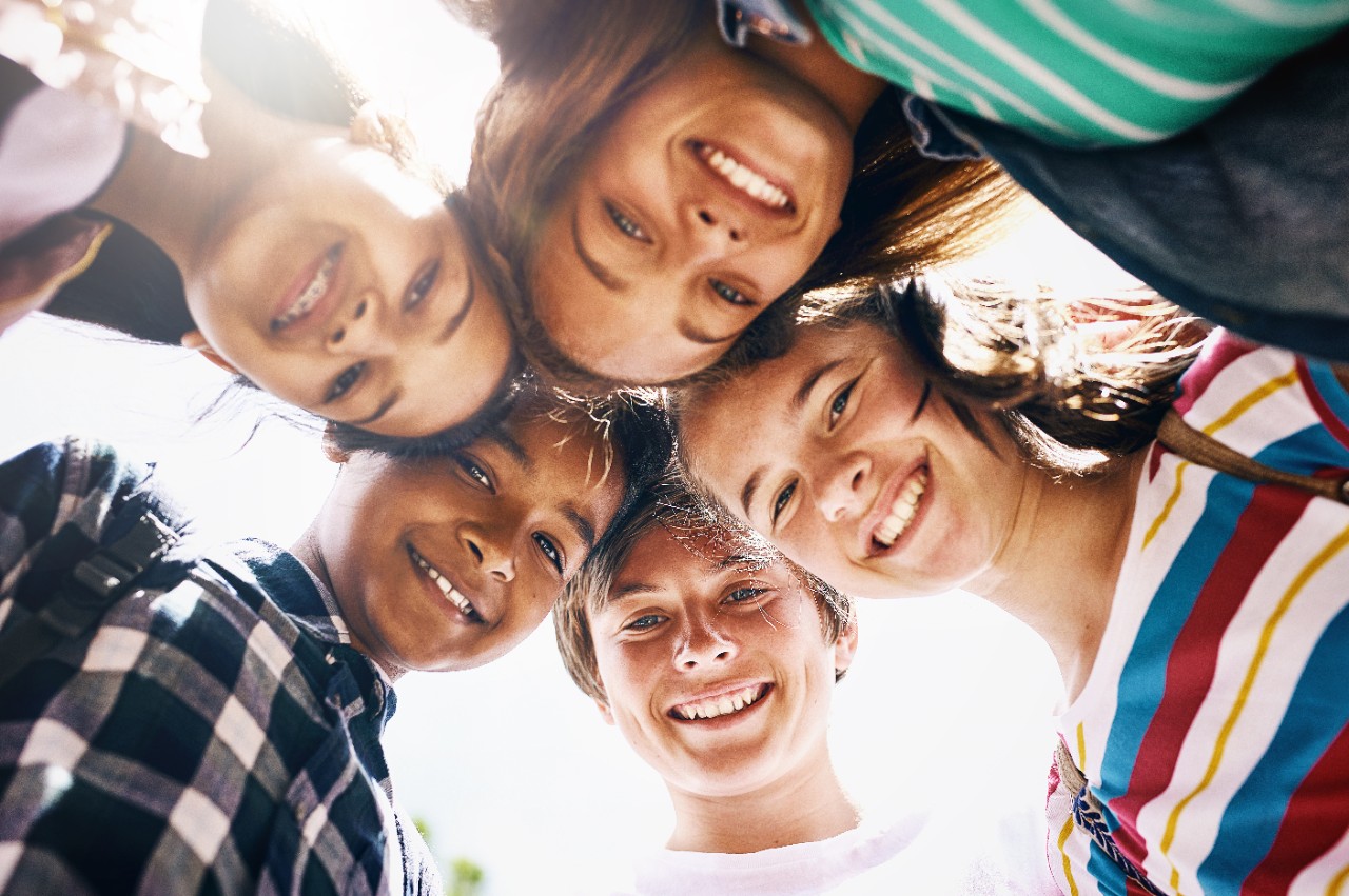 Tomorrow belongs to us. Low angle portrait of a group of diverse schoolchildren standing in a huddle. Low angle portrait of a group of diverse schoolchildren standing in a huddle.