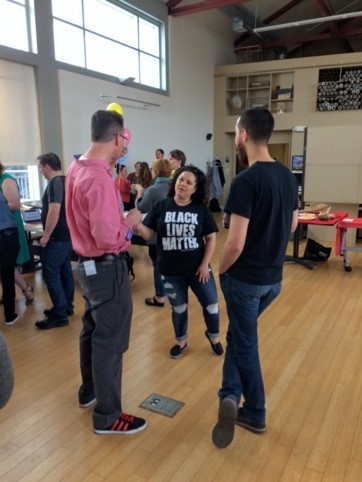 This is a picture of two men talking to women in a black lives matter tee-shirt
