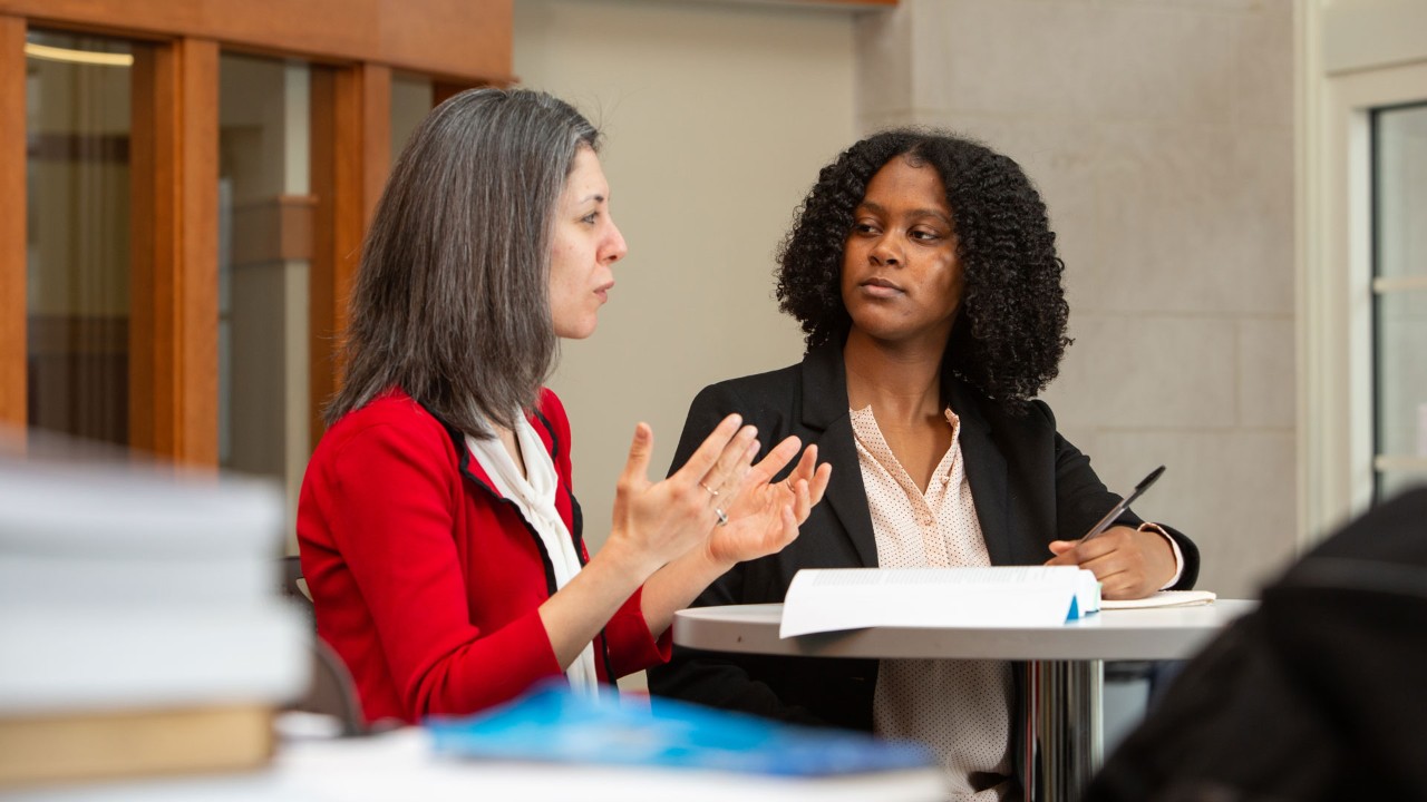 Two women sit and talk thoughtfully